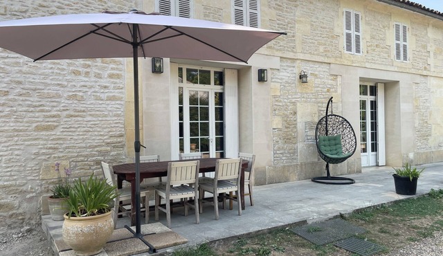 Typical Charente farmhouse with enclosed garden planted with trees.